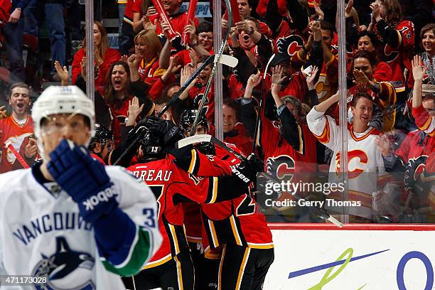 Johnny Gaudreau, Sean Monahan and teammates of the Calgary Flames celebrate a goal against the Vancouver Canucks at Scotiabank Saddledome for Game...