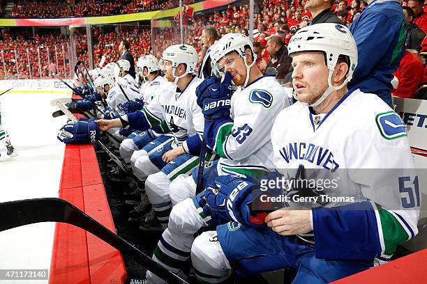 Derek Dorsett, Henrik Sedin and teammates of the Vancouver Canucks sit on the bench in between shifts against the Calgary Flames at Scotiabank...