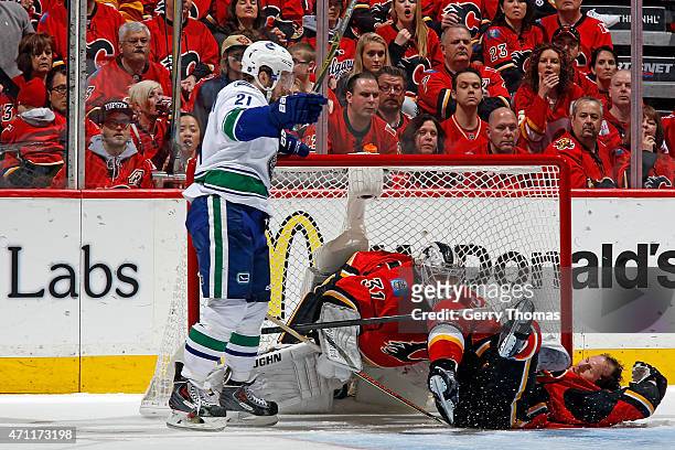Brandon McMillan of the Vancouver Canucks knocks down Dennis Wideman of the Calgary Flames at Scotiabank Saddledome for Game Six of the Western...