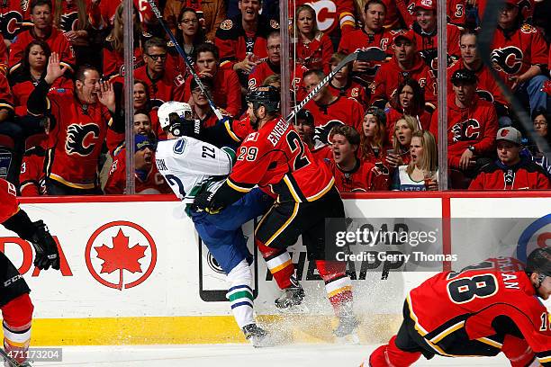 Deryk Engelland of the Calgary Flames checks Daniel Sedin of the Vancouver Canucks at Scotiabank Saddledome for Game Six of the Western Quarterfinals...