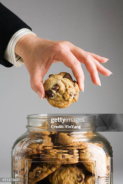 corporate hand in cookie jar - pot met koekjes stockfoto's en -beelden