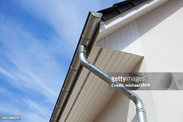 architectural close-up of a metal rain gutter with downspout - goot stockfoto's en -beelden