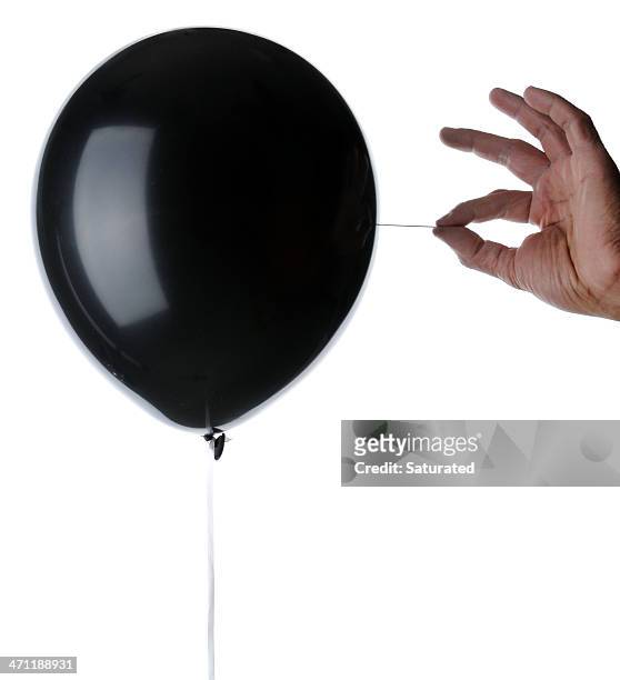 balloon about to be popped with a needle - black balloons stock pictures, royalty-free photos & images