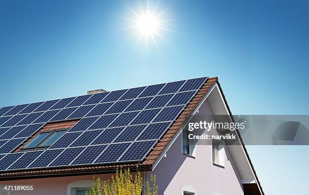 house with solar panels on the roof - zonne energie stockfoto's en -beelden
