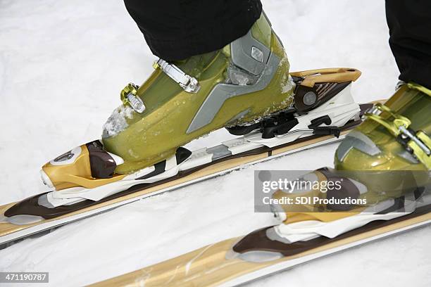 skiier putting on skis - skischoen stockfoto's en -beelden