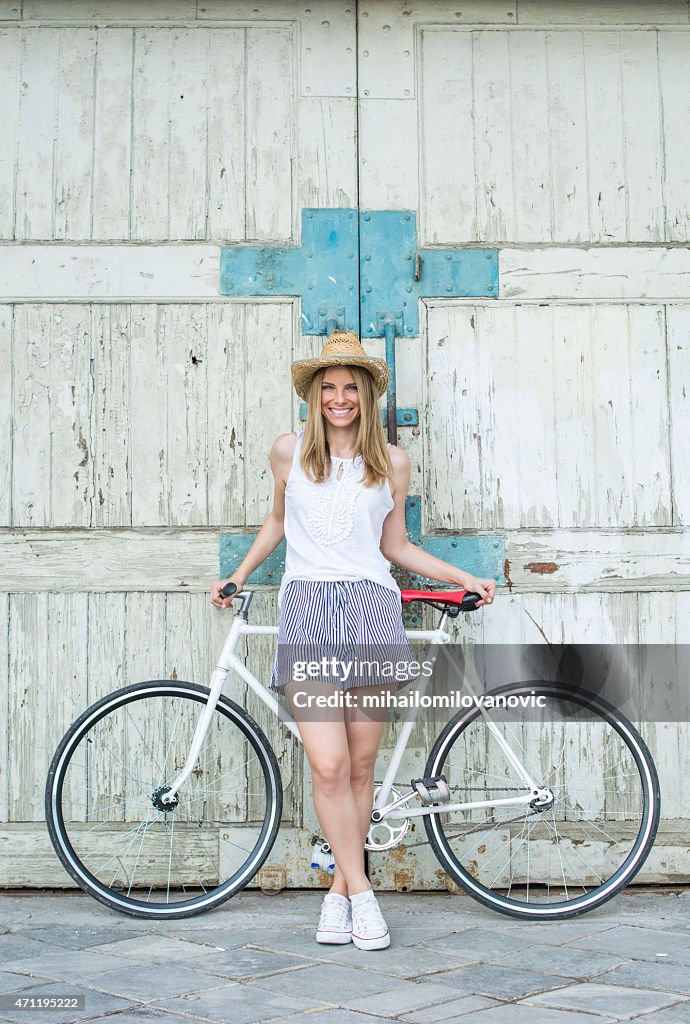 Bella ragazza in posa con la bicicletta