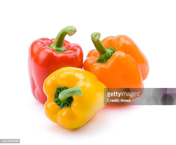 red, yellow, and orange bell peppers - peper groente stockfoto's en -beelden