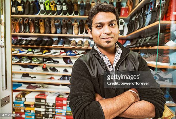 young man selling shoes at a shopping mall - shoe shop assistant stock pictures, royalty-free photos & images