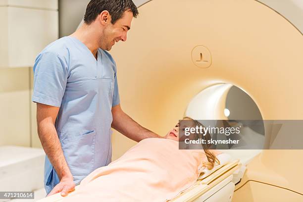 smiling radiologist talking to little girl before an mri scan. - radiotherapy stock pictures, royalty-free photos & images