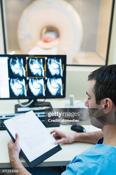 radiologist examining results of mri scan. - medical scan stock pictures, royalty-free photos & images