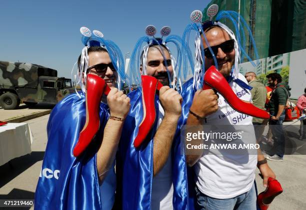Lebanese men pose with their shoes before taking part in a mile-long walk in women's high heels during the "Walk a Mile in her Shoes" event to call...
