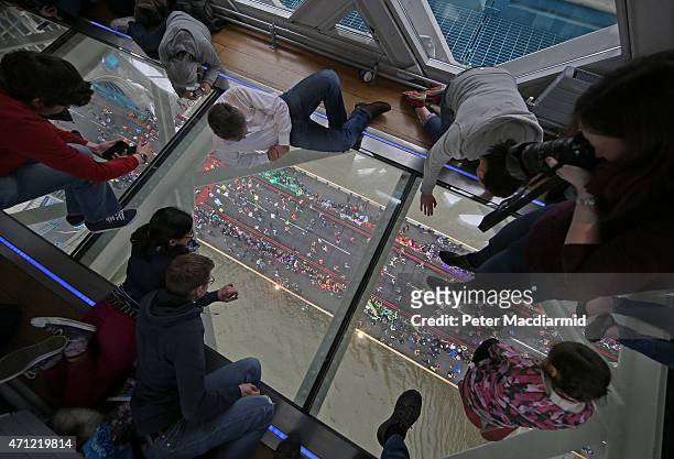 Runners on The Virgin Money London Marathon cross the River Thames as seen from The Tower Bridge Exhibitions Glass Flooring on April 26, 2015 in...
