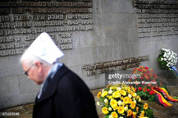 Contemporary witness walks by a memorial plaque during a ceremony to commemorate the 70th anniversary of the liberation of the Bergen-Belsen...