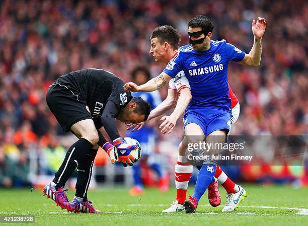 Goalkeeper David Ospina and Laurent Koscielny of Arsenal foil Cesc Fabregas of Chelsea during the Barclays Premier League match between Arsenal and...