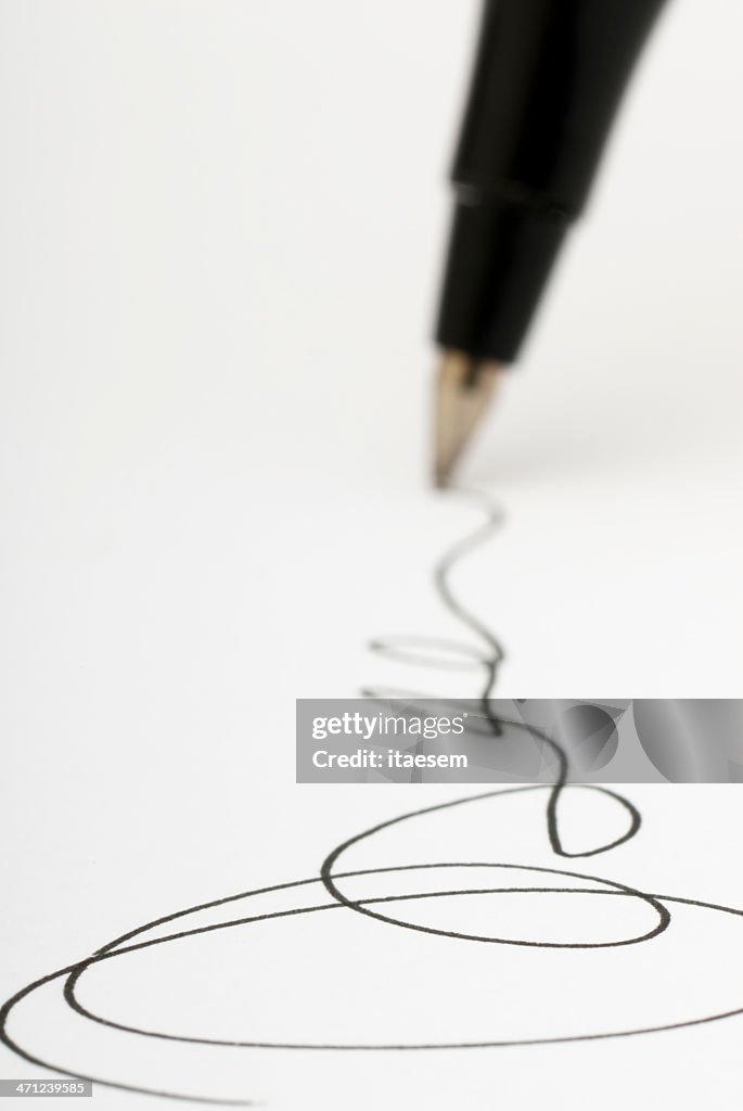 Closeup shot of pen writing signature on white paper