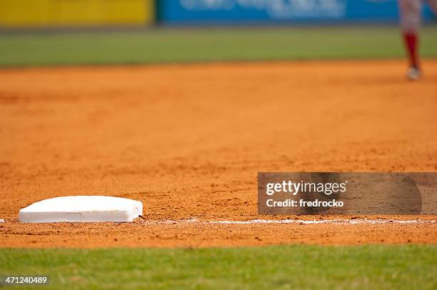 baseball-spieler laufen zum dritten mal über baseball field während baseball-spiel - baseball base stock-fotos und bilder