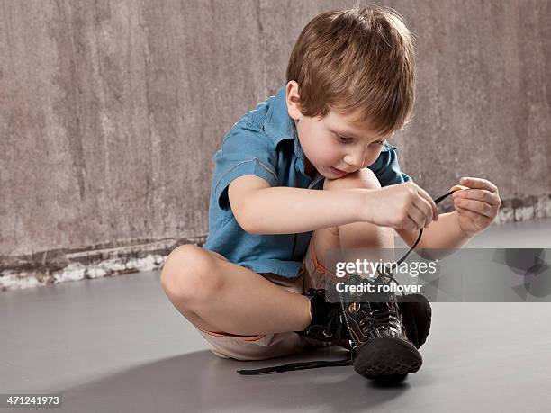 lernen und wachsen - boy tying shoes stock-fotos und bilder