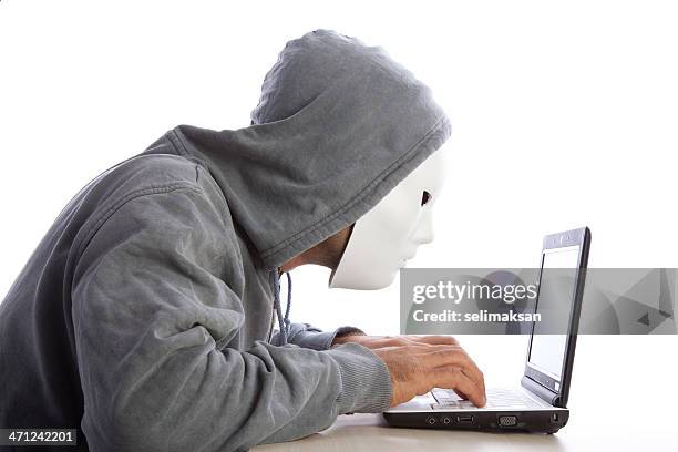 man with mask and hood using computer, internet security concept - scheme stock pictures, royalty-free photos & images