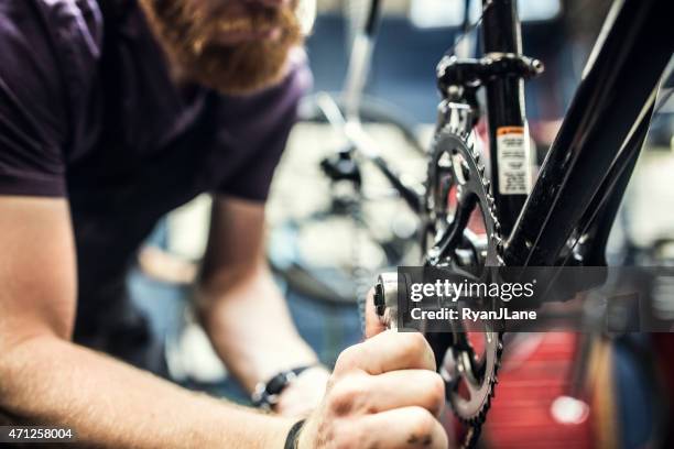 bicycle repair shop and man working - bicycle repair stock pictures, royalty-free photos & images