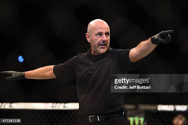 Referee Yves Lavigne signals to UFC flyweight champion Demetrious 'Mighty Mouse' Johnson and Kyoji Horiguchi of Japan in their UFC flyweight...