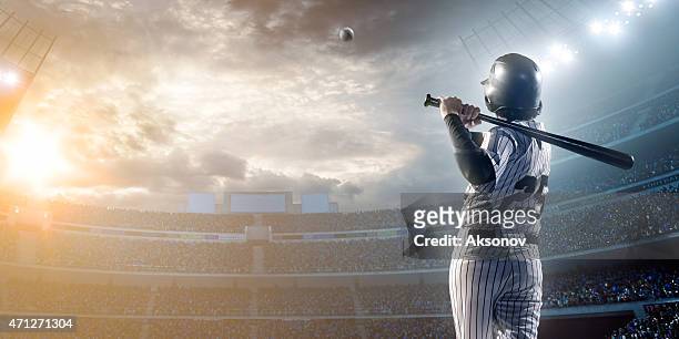 baseball player hitting a ball in stadium - baseball sport stock pictures, royalty-free photos & images