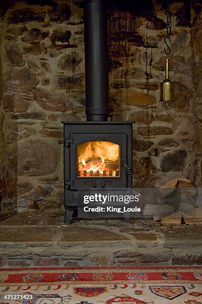 a wood-burning stove inside of an older home  - wood burning stove stockfoto's en -beelden