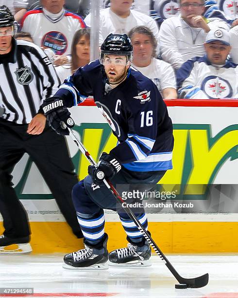 Andrew Ladd of the Winnipeg Jets plays the puck down the ice during overtime against the Anaheim Ducks in Game Three of the Western Conference...