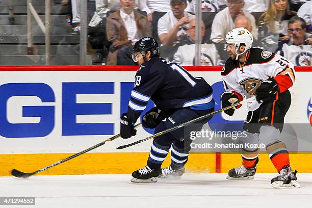 Jim Slater of the Winnipeg Jets plays the puck along the boards away from Kyle Palmieri of the Anaheim Ducks in Game Three of the Western Conference...