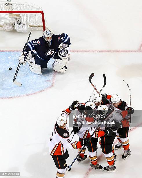 Goaltender Ondrej Pavelec of the Winnipeg Jets looks on as the Anaheim Ducks celebrate a second-period goal in Game Three of the Western Conference...