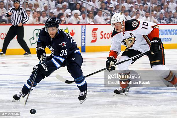 Toby Enstrom of the Winnipeg Jets and Corey Perry of the Anaheim Ducks chase the puck down the ice during first-period action in Game Three of the...