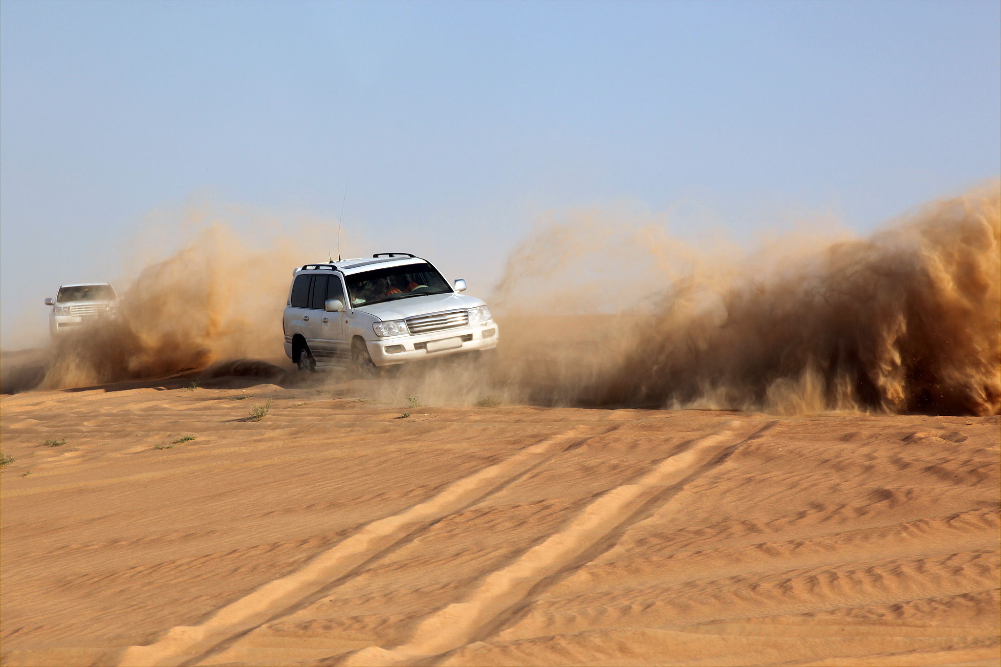 Sports Utility Vehicle speeding in desert sand, Dubai, UAE Sports Utility Vehicle speeding in desert sand, Dubai, UAE