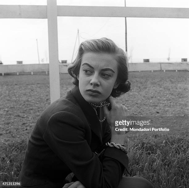 Anna Maria Ferrero, the artistic name of Anna Maria Guerra the famous Italian film and television actress, poses next to a fence gazing into the...