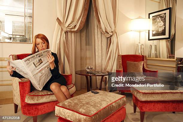 The Italian Minister of Tourism Michela Vittoria Brambilla seats on a red sofa reading a newspaper in the suite of the Savoia Hotel, where she...
