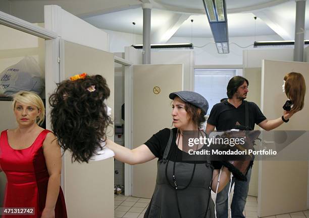 Katia Follesa, Maria Di Biase and Alessandro Betti, young Italian comic actors known thanks to the tv show Zelig, hold some wigs in the dressing...