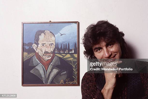Italian rocker Luciano Ligabue, come adulto to success and on his second album at the time the photo was taken, poses alongside a self-portrait of...
