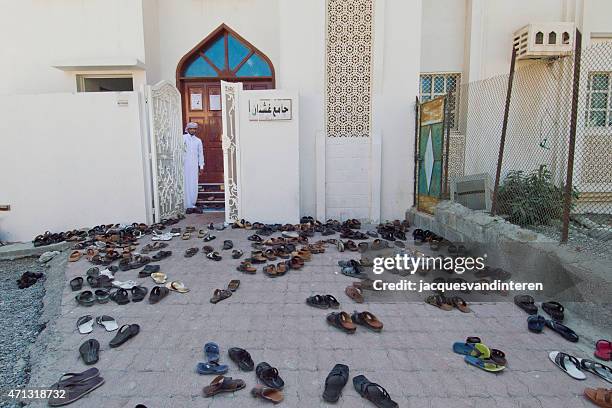 shoes in front of the mosque in kumzar, musandam, oman - kumzar stockfoto's en -beelden