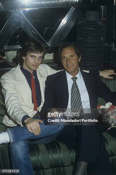 Spanish-born Italian singer and TV presenter Miguel Bos sitting on a sofa with his father and Spanish torero Luis Miguel Dominguin . Spain, 1980