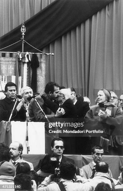 The maior of Bologna Renzo Imbeni and the President of the Italian Republic Sandro Pertini hugging each other watched by the President of the Chamber...