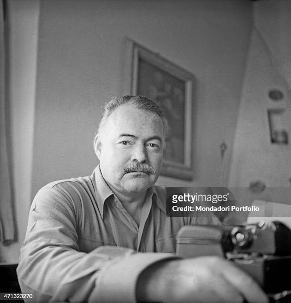 Portrait of American writer and journalist Ernest Hemingway beside a typewriter. Rome, 1949