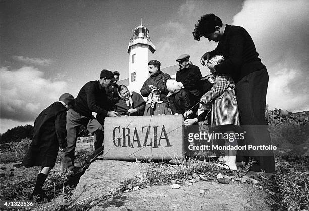 Italian journalist and correspondent of the weekly magazine Grazia Giorgio Torelli being surrounded by people at lighthouse of Capel Rosso. In the...