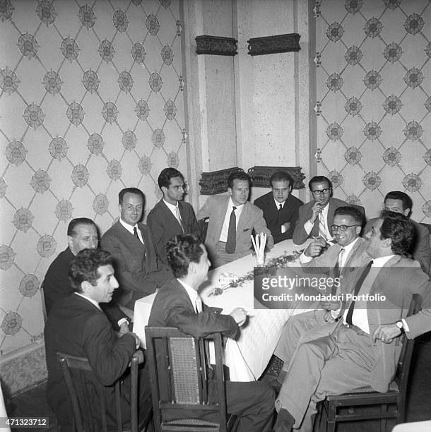 Italian writers Giorgio Bassani and Italo Calvino sitting at the table with some other writers at the Incontri Letterari, former San Pellegrino...