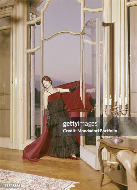 Italian singer and actress Milva posing in a livingroom of Villa Castelli in an evening dress with fur applications made by Italian dressmaker and...