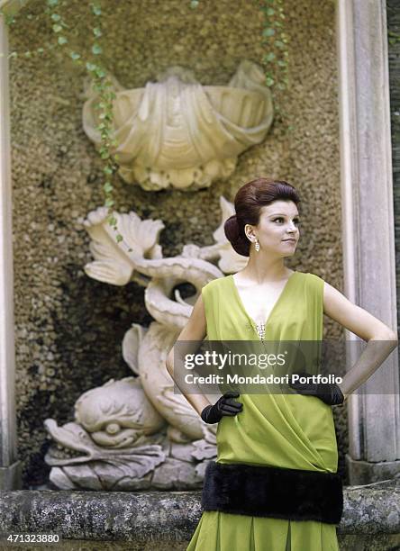 Italian singer and actress Milva posing in the garden of Villa Castelli in a green dress with fur applications made by Italian dressmaker and fashion...