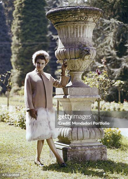Italian singer and actress Milva posing in the garden of Villa Castelli in a pale pink coat with fur applications made by Italian dressmaker and...