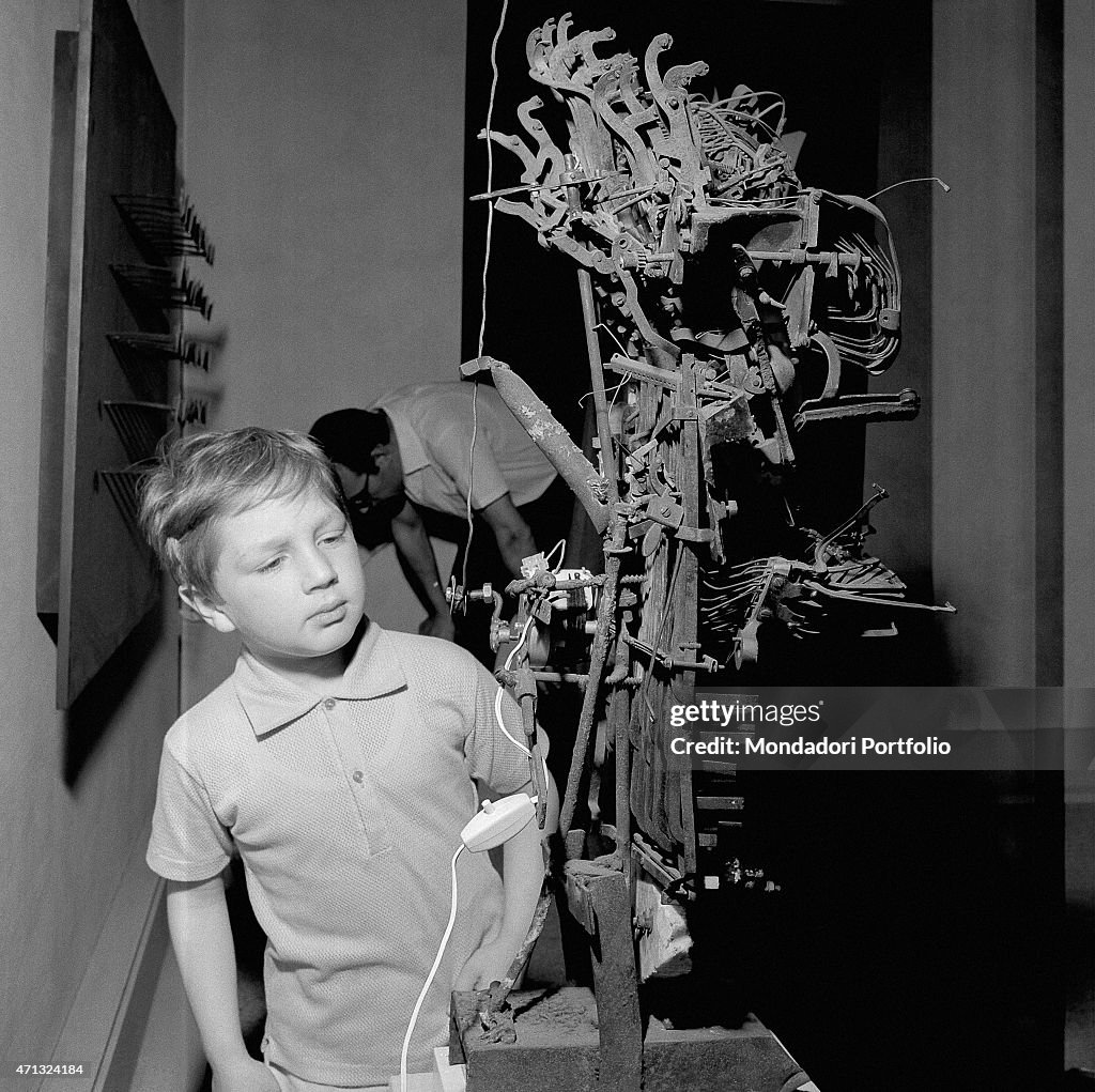 A child observing Olympia 60 by Yves Tanguy at the 32nd Art Biennale