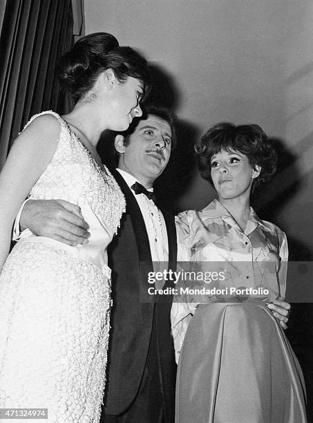 Italian singer-songwriter and actor Domenico Modugno hugging Italian singers Gigliola Cinquetti and Ornella Vanoni at 16th Sanremo Music Festival....