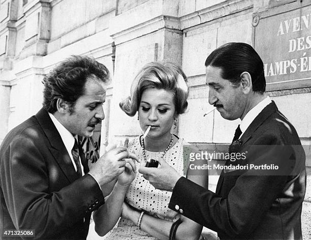 Spanish actor and musician Don Jaime de Mora y Aragon, also known as Fabiolo lighting a cigarette to Italian actress and circus artist Liana Orfei...