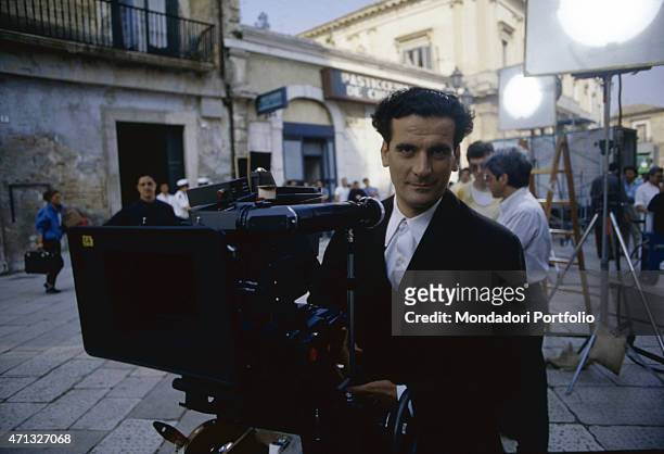 Italian actor and director Massimo Troisi using a camera on the set of the film Le vie del Signore sono finite. 1987
