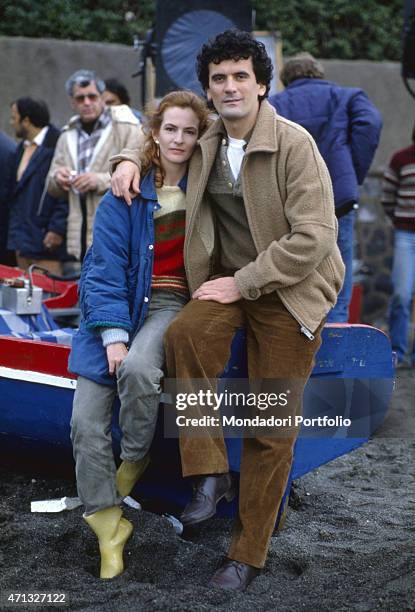 Italian actor and director Massimo Troisi hugging Italian actress Giuliana De Sio on the set of the film Scusate il ritardo. 1983