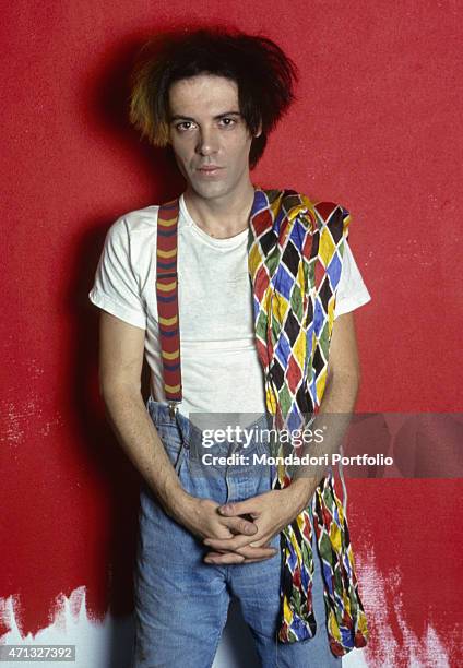 Italian singer-songwriter, guitarist and theatre artist Alberto Camerini posing for a photo shooting wearing suspenders and keeping Arlecchino's...